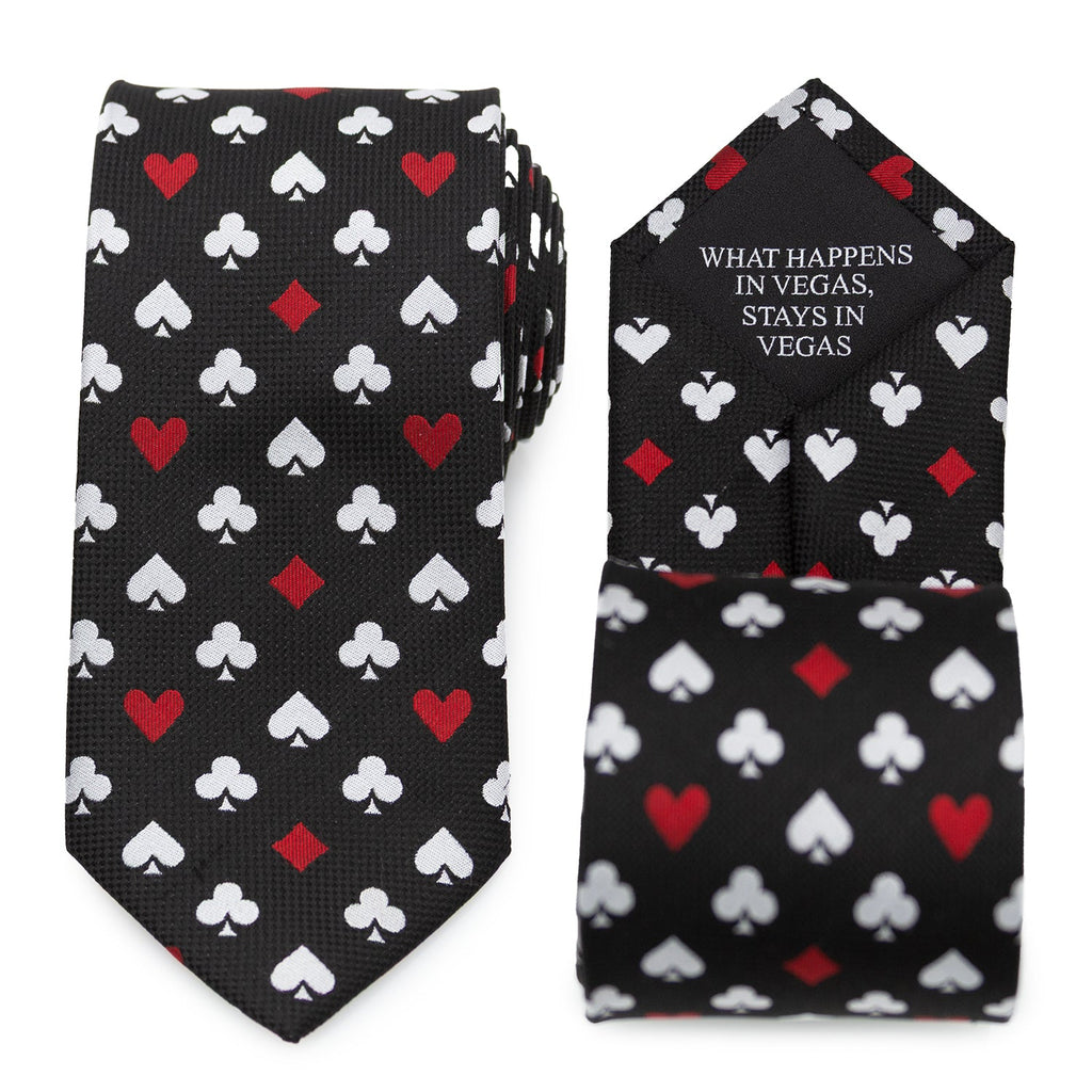 Close up of a black necktie featuring a repeating pattern of white and red playing card suits, with a hidden message on the back