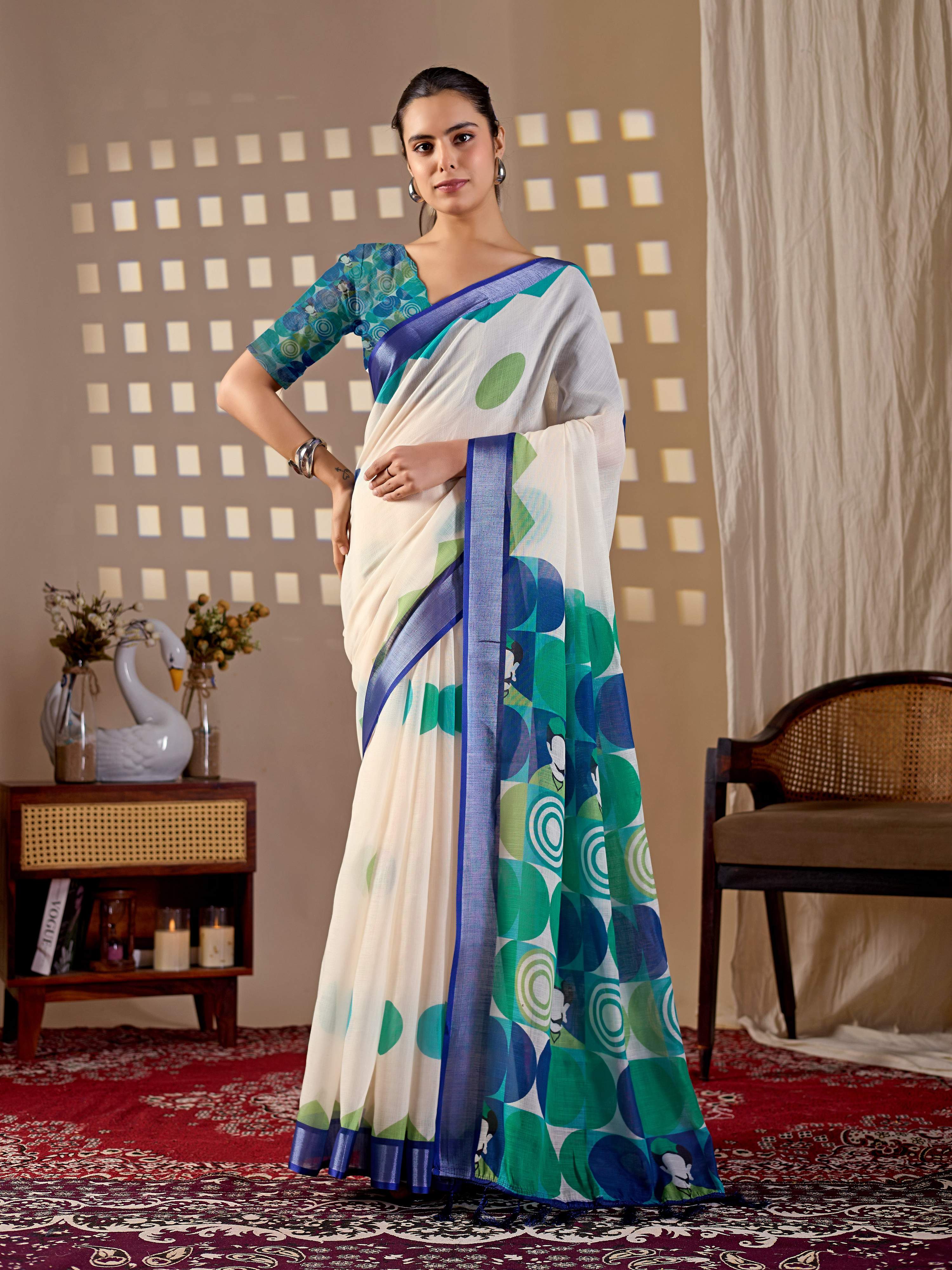 A chic cream linen cotton printed saree styled with a refreshing aqua blue blouse.