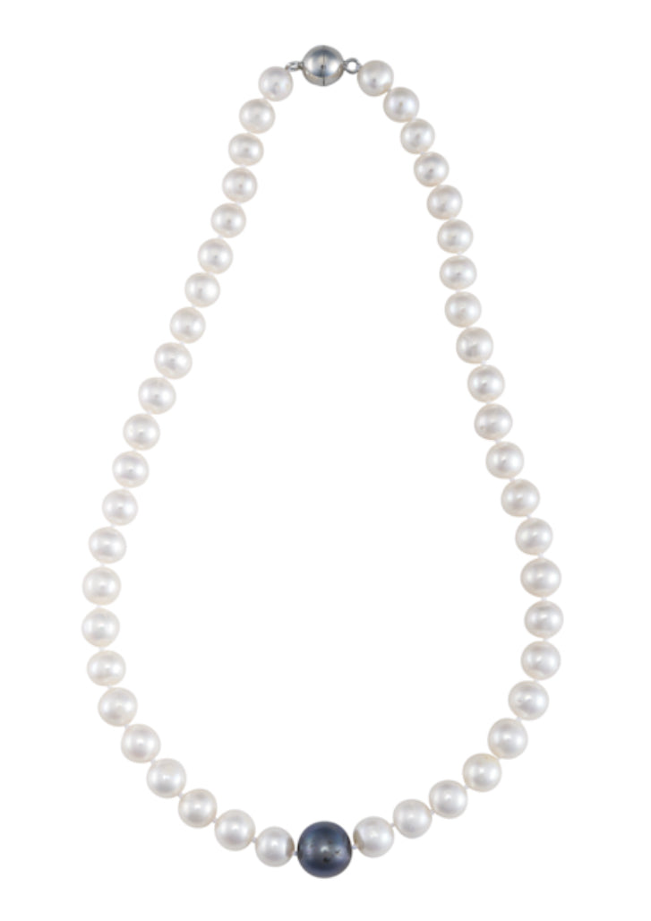 An 18-inch strand of white freshwater pearls with a larger black central pearl and a magnetic clasp.