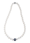 An 18-inch strand of white freshwater pearls with a larger black central pearl and a magnetic clasp.