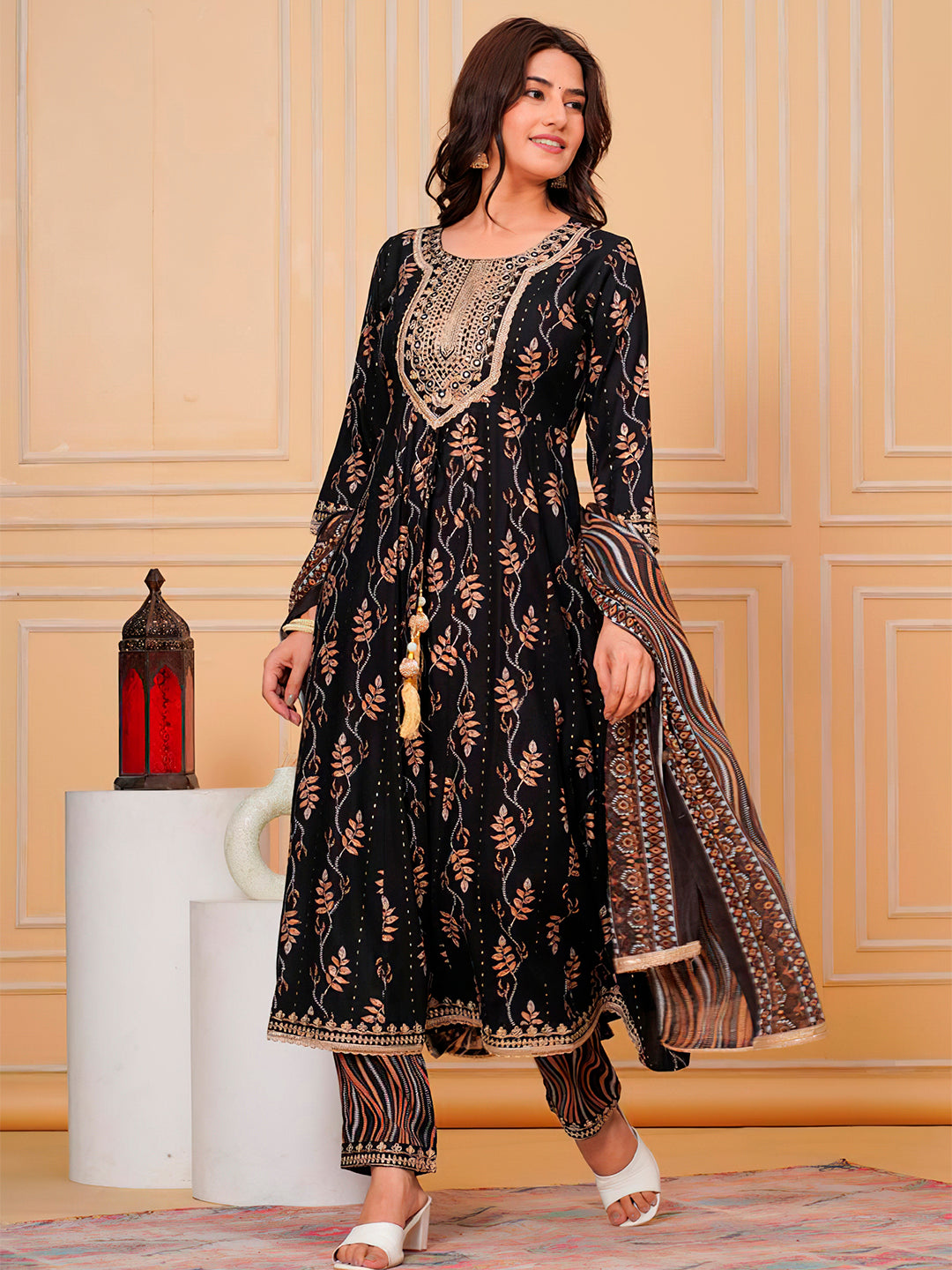 A premium black flared kurta featuring intricate embroidery and leaf print patterns with matching pants.