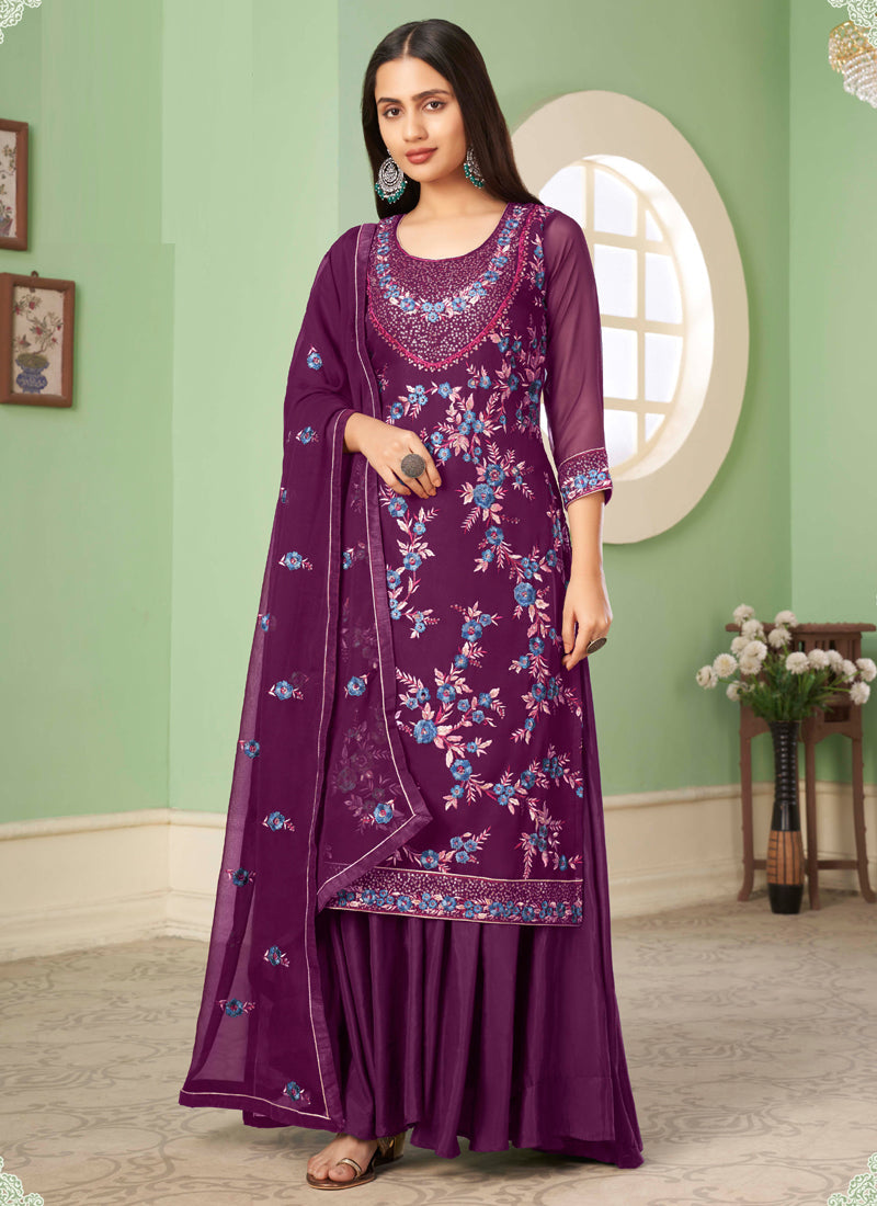 Woman wearing a violet floral embroidered A-line sharara suit with matching dupatta