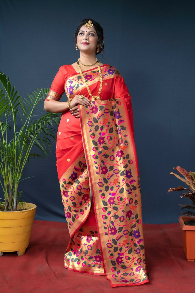 Women wearing a vibrant red Paithani silk saree with intricate gold zari woven details and a matching blouse.