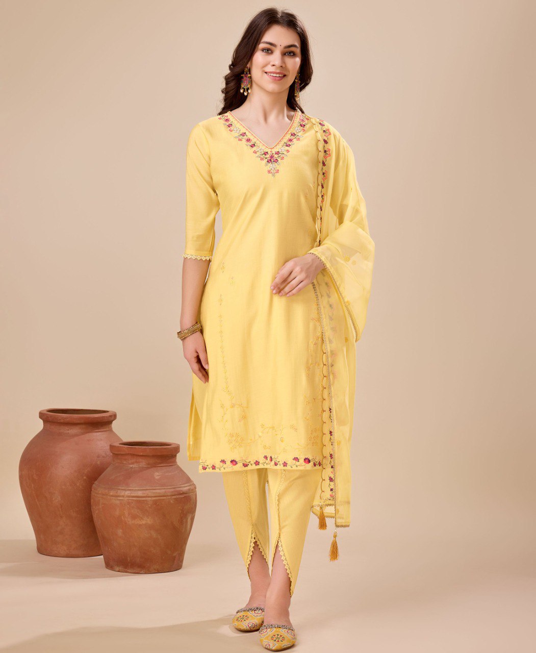 Woman wearing a yellow viscose silk embroidered kurta paired with stylish dhoti pants and a matching dupatta.