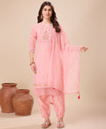 A woman wearing a peach viscose silk embroidered kurta set with an Afghani salwar and matching dupatta.