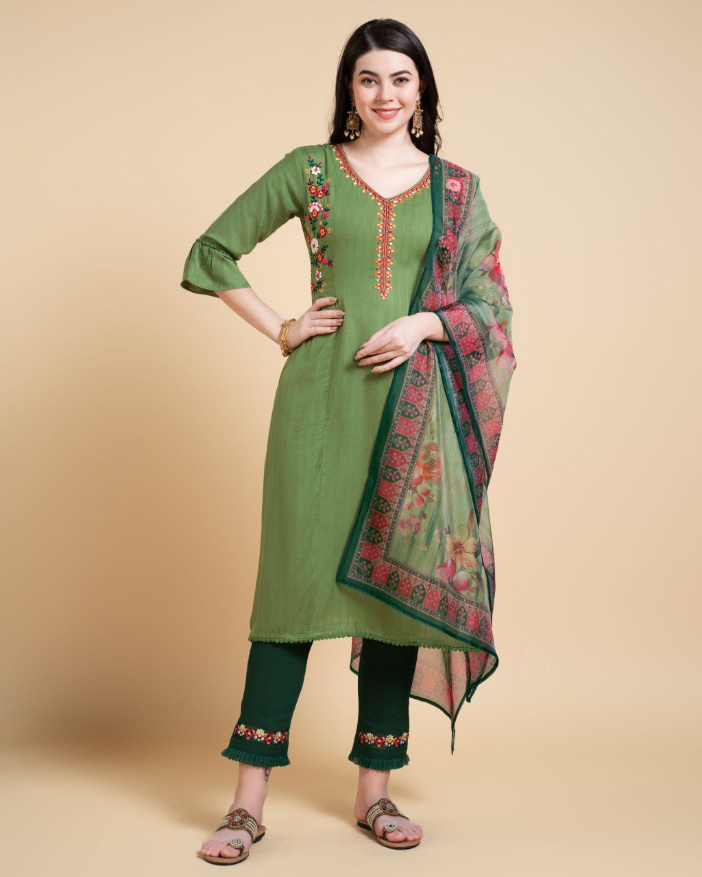 Woman wearing a Mahendi colored rayon kurta set featuring floral embroidery.