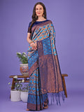 Woman wearing a Radiant Lichi Silk Saree with geometric patterns in blue, copper, and grey shades.