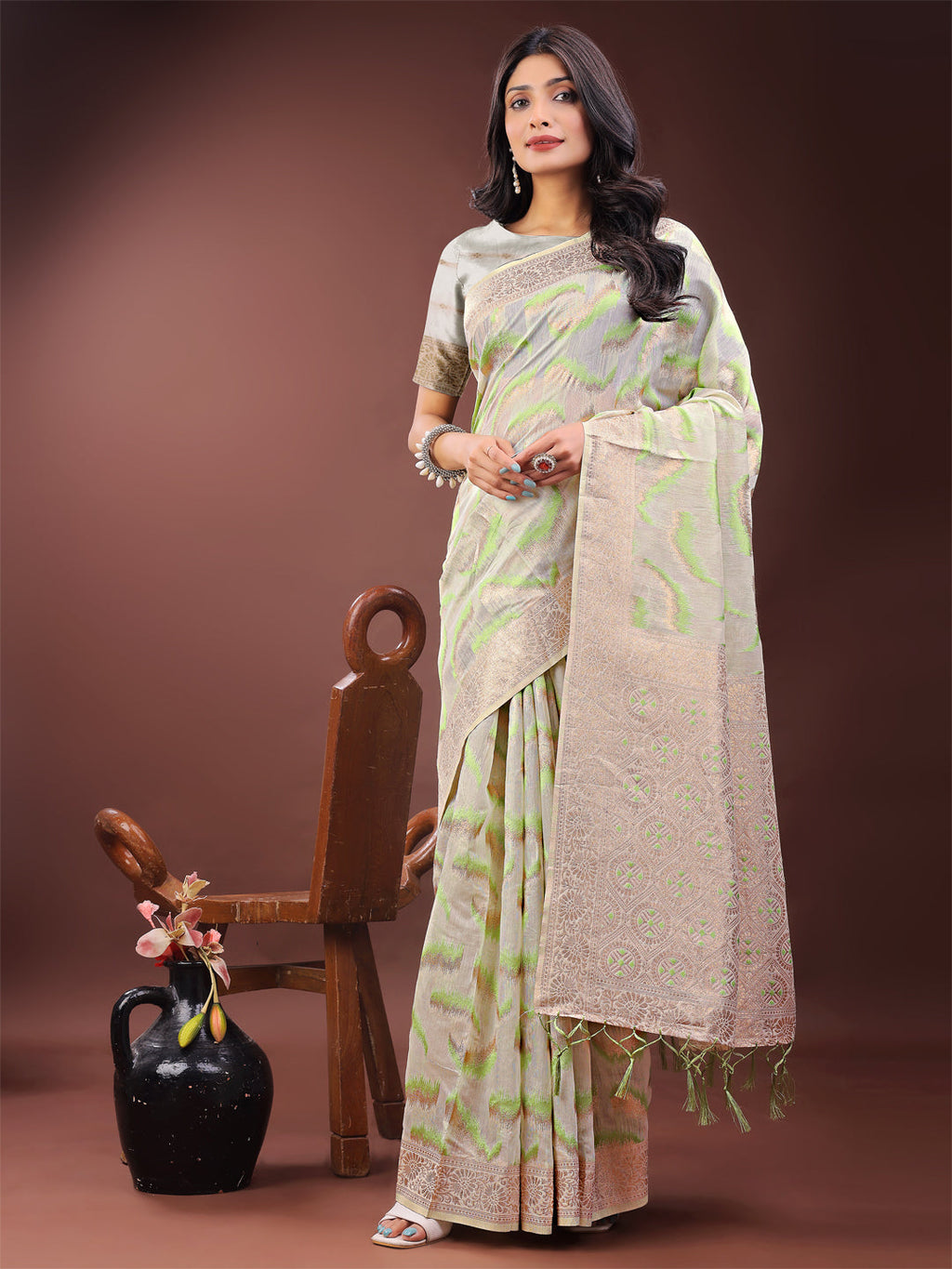 Elegant beige and coral linen saree featuring an abstract print and a traditional Zari border.