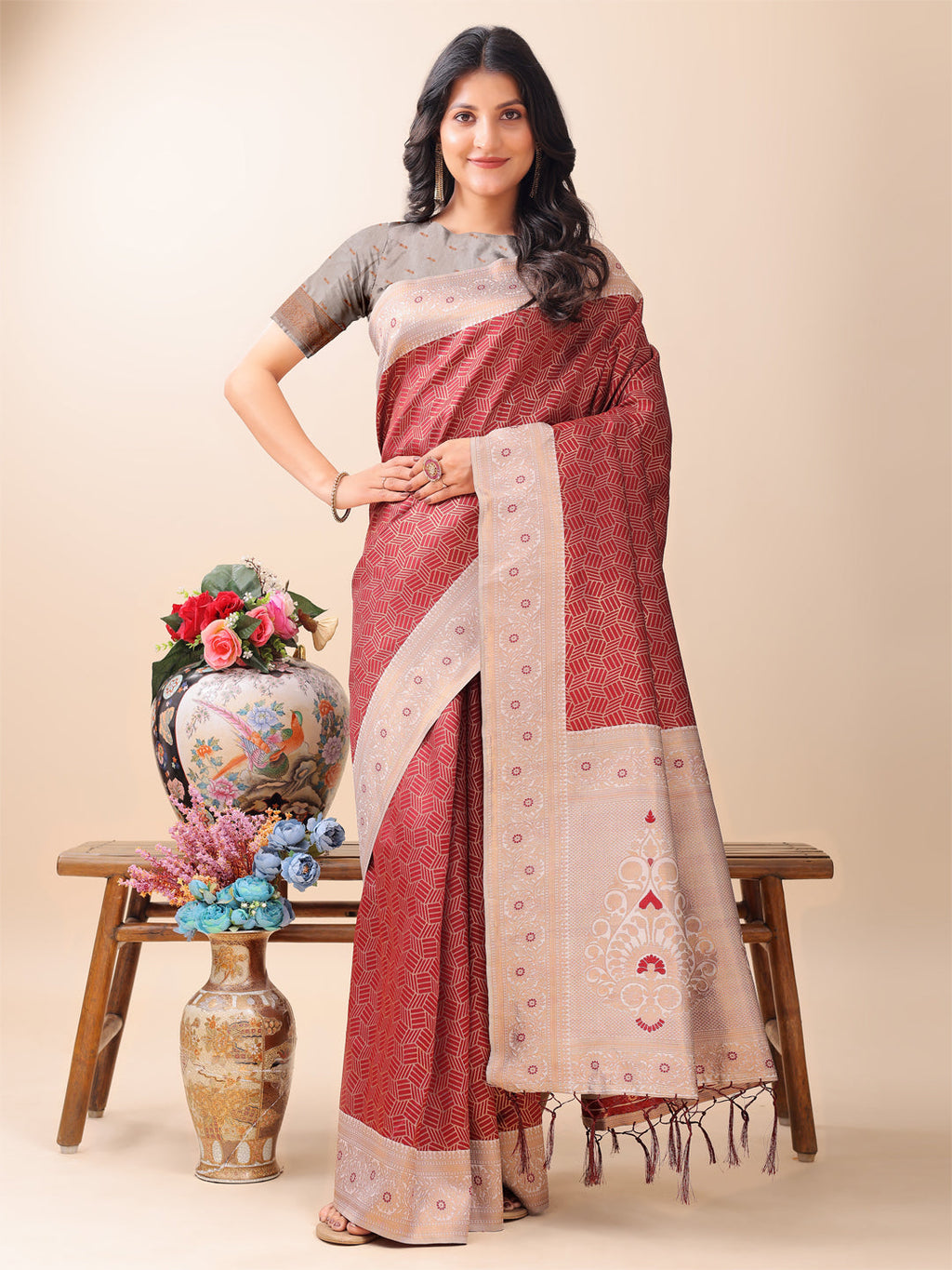 A graceful maroon and beige Lichi silk saree featuring an intricate woven pallu draped elegantly.