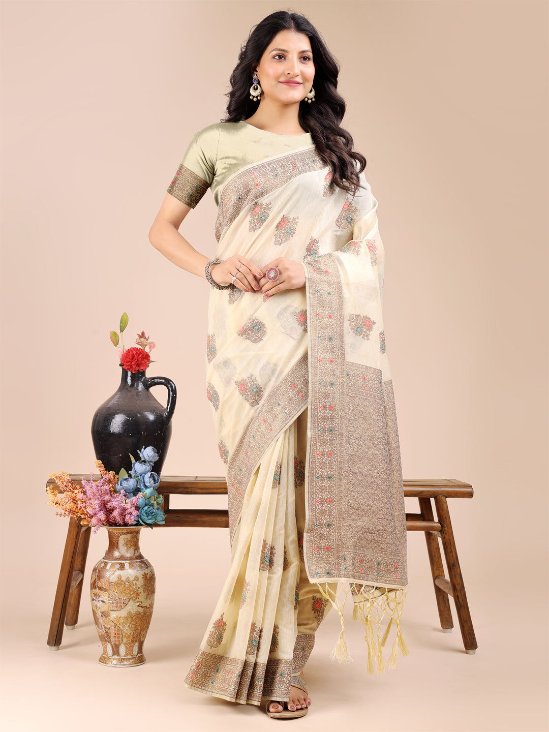 Traditional cream cotton saree with woven zari details and decorative tassels