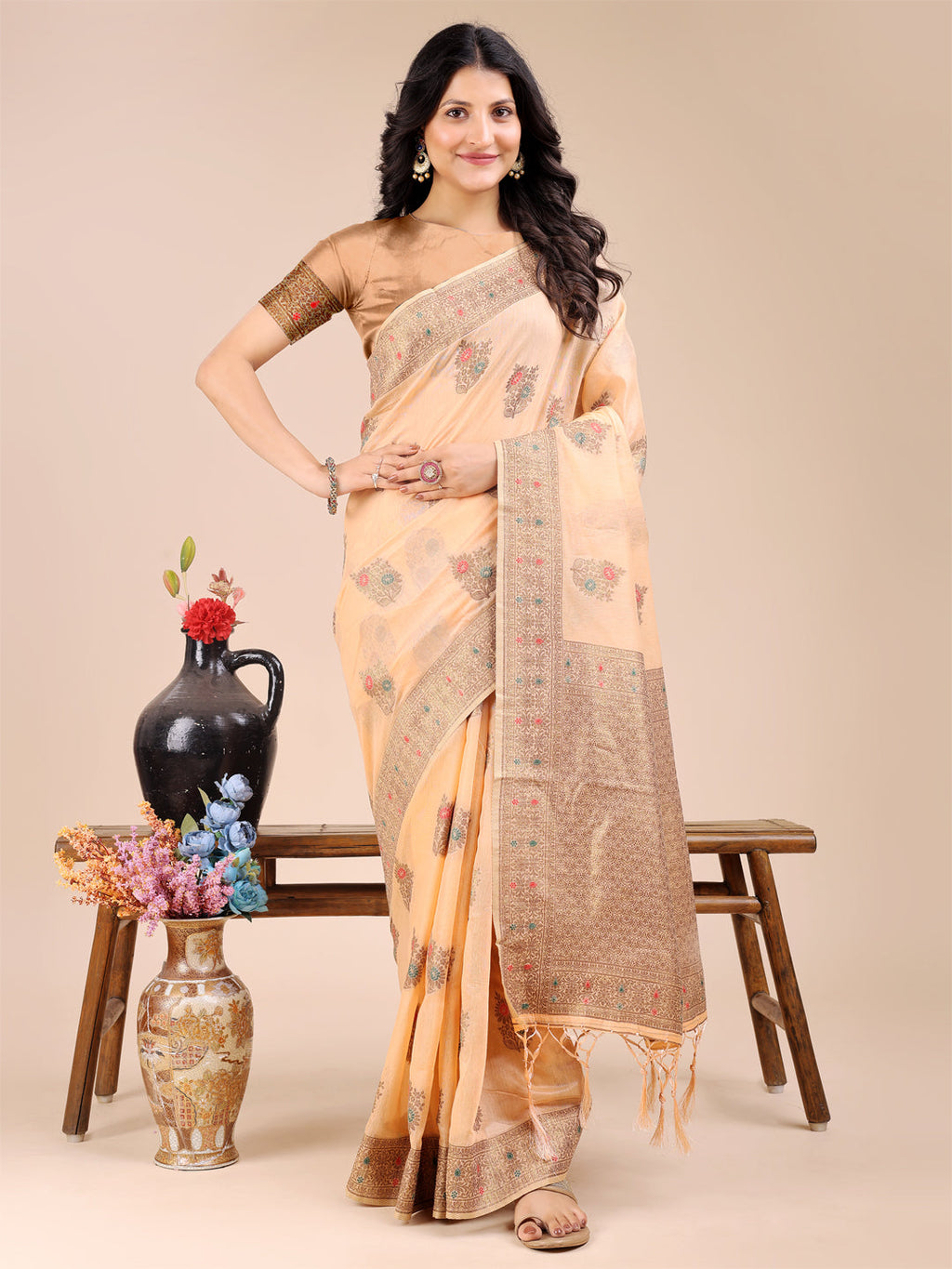 Peach cotton saree with gold woven zari borders and decorative tassel ends