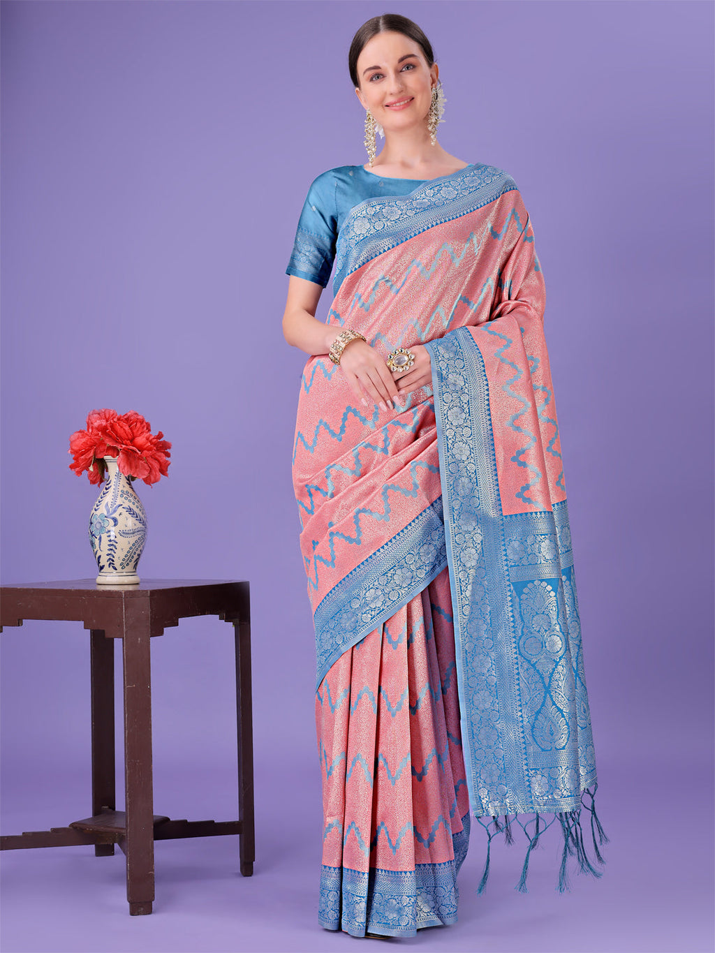 Peach and blue lichi silk saree featuring a geometric zigzag pattern and heavy woven border