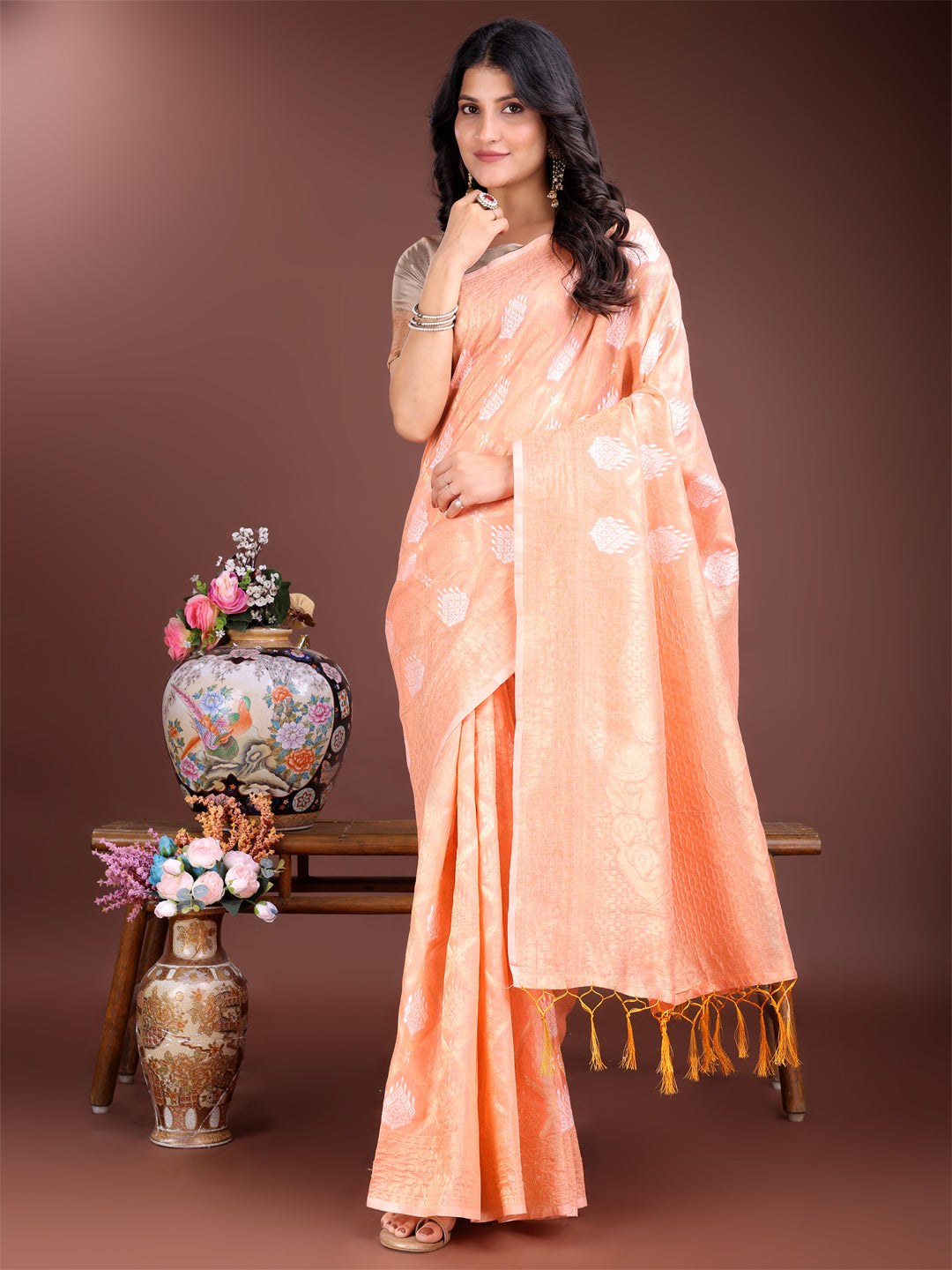 Vibrant orange cotton saree featuring intricate gold Zari work and traditional tassels.