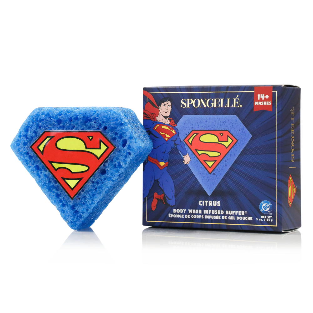 A blue diamond-shaped Superman body wash infused sponge next to its branded DC Comics packaging.