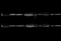 Close up of the handle and reel seat area of a black AttaX Pro Series baitcasting fishing rod against a black background.