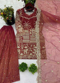 Woman wearing a Gajri pink organza palazzo suit with heavy gold embroidery and sequence work