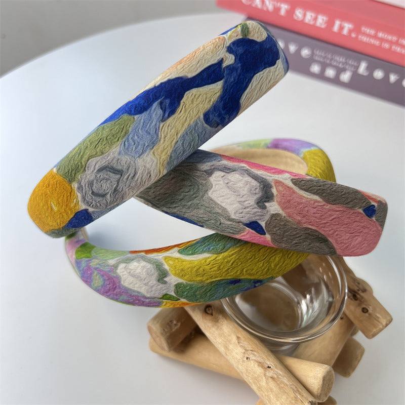 Wide graffiti abstract pattern sponge headband in multicolor (blue, yellow, pink, green) on a white background