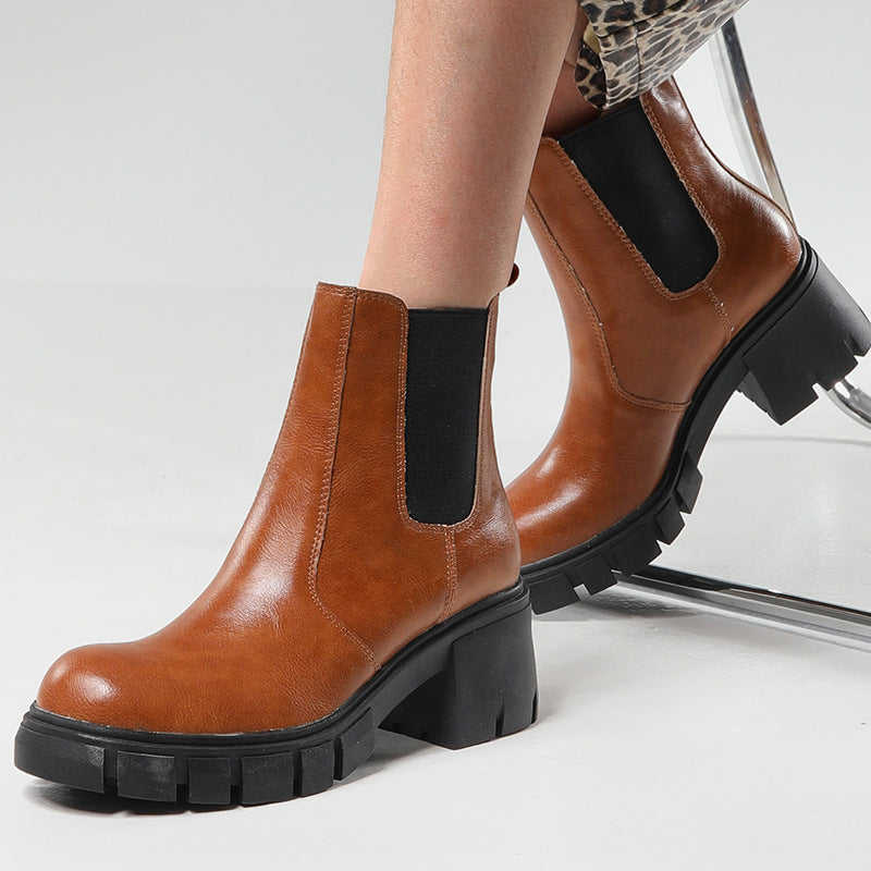 A pair of women's chunky lug sole Chelsea boots in brown, worn with leopard print pants, and a standalone black chunky lug sole Chelsea boot product shot.