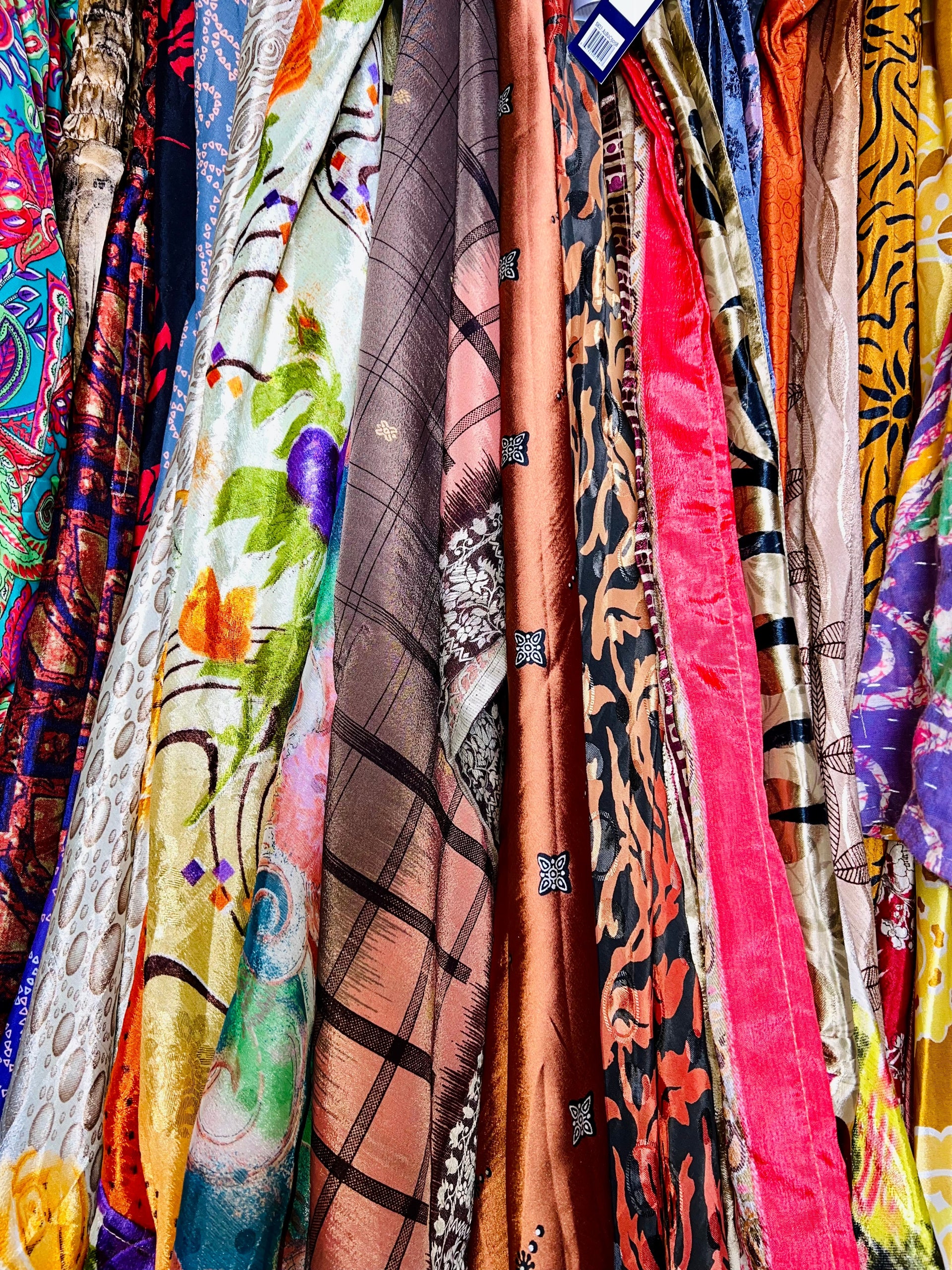 A vibrant assortment of bohemian-style clothing and accessories included in a Darn Good Yarn mystery bundle.