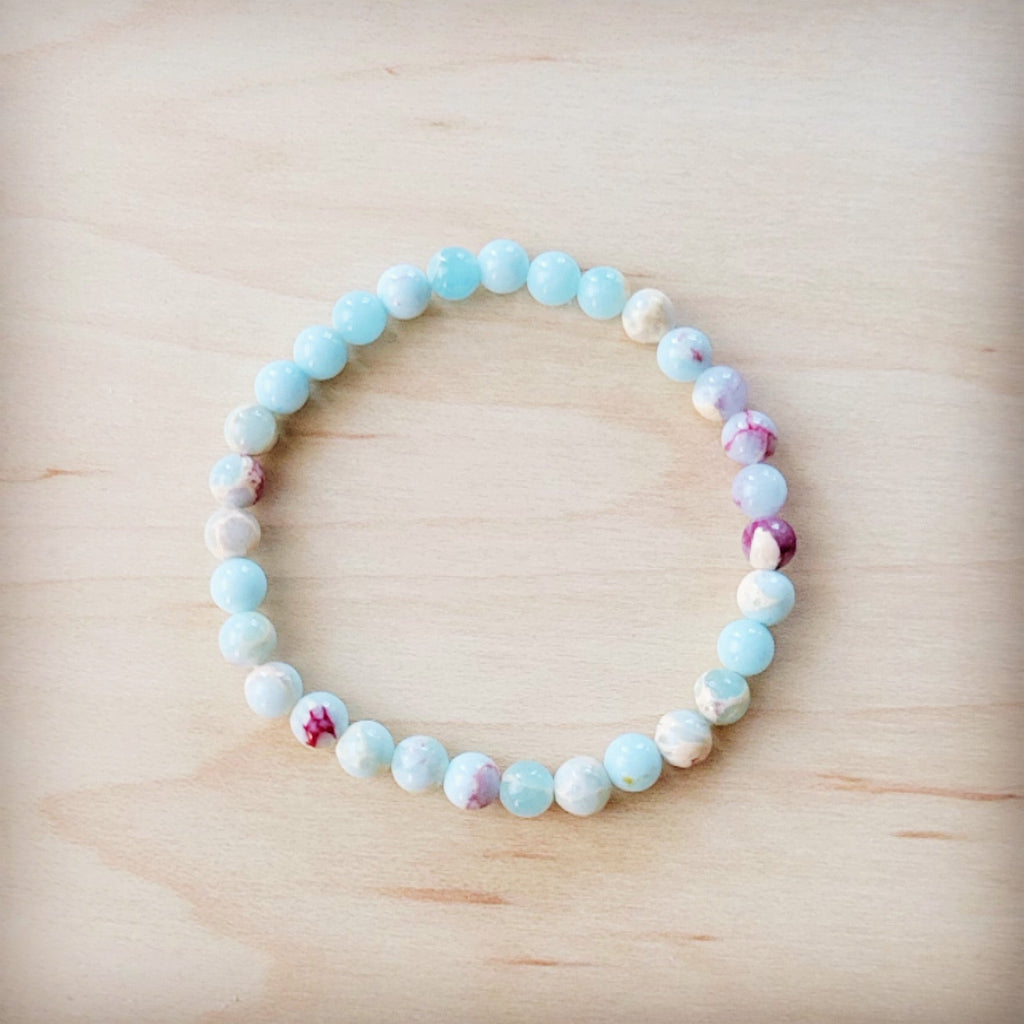 Pastel Aqua Terra Jasper beaded stretch bracelet on a light wood background