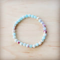 Pastel Aqua Terra Jasper beaded stretch bracelet on a light wood background
