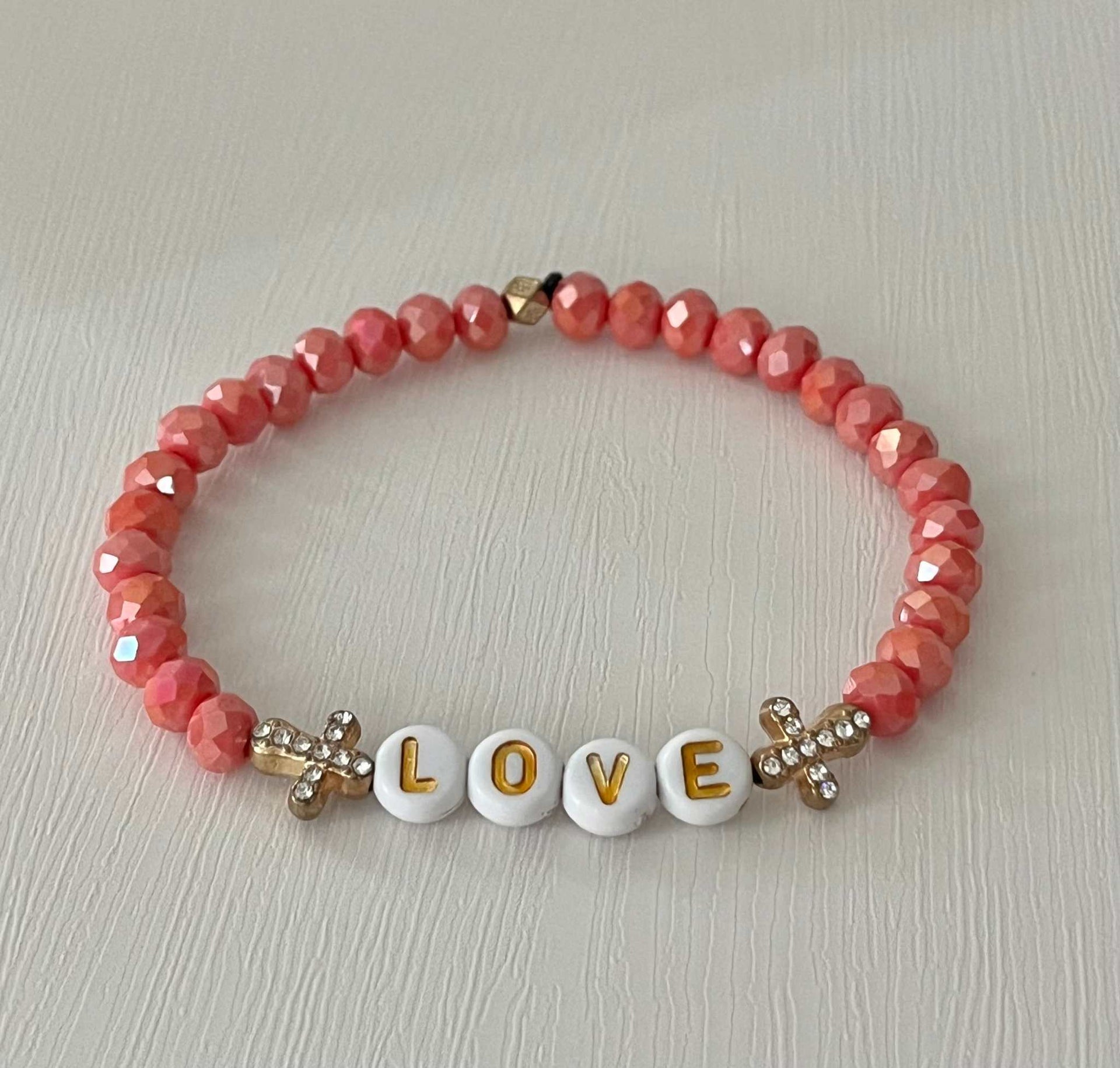 Love Red Glass Bead Bracelet featuring alternating red glass beads and gold cross charms.