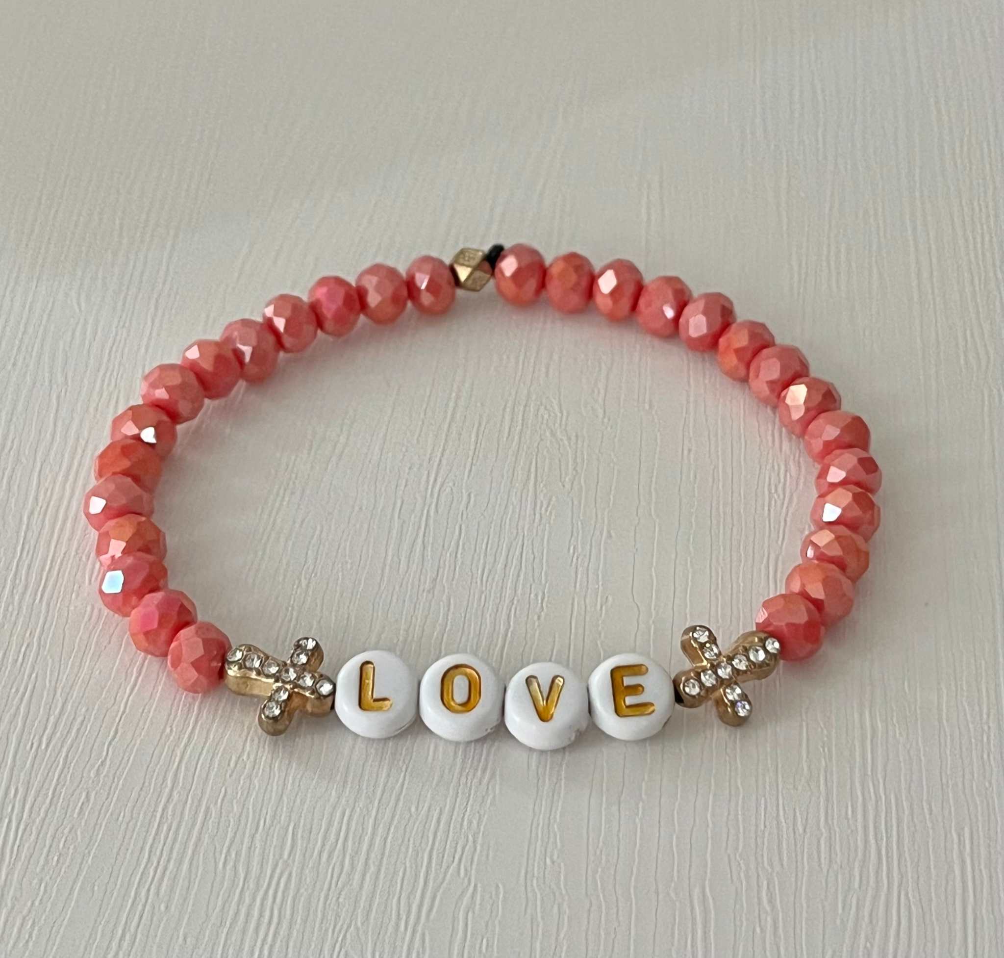 Love Red Glass Bead Bracelet featuring alternating red glass beads and gold cross charms.
