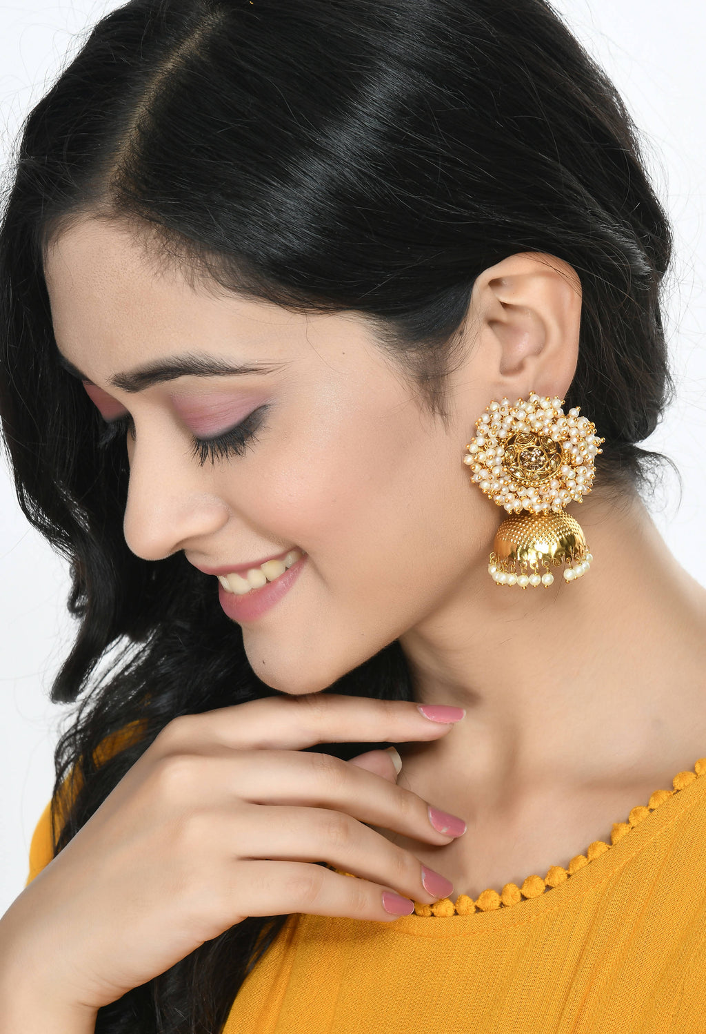 Little girl wearing gold-polished bead jhumka earrings with traditional party outfit