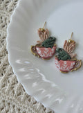 A pair of artisan-made Teacup Frog Earrings in Rose polymer clay with gold hardware