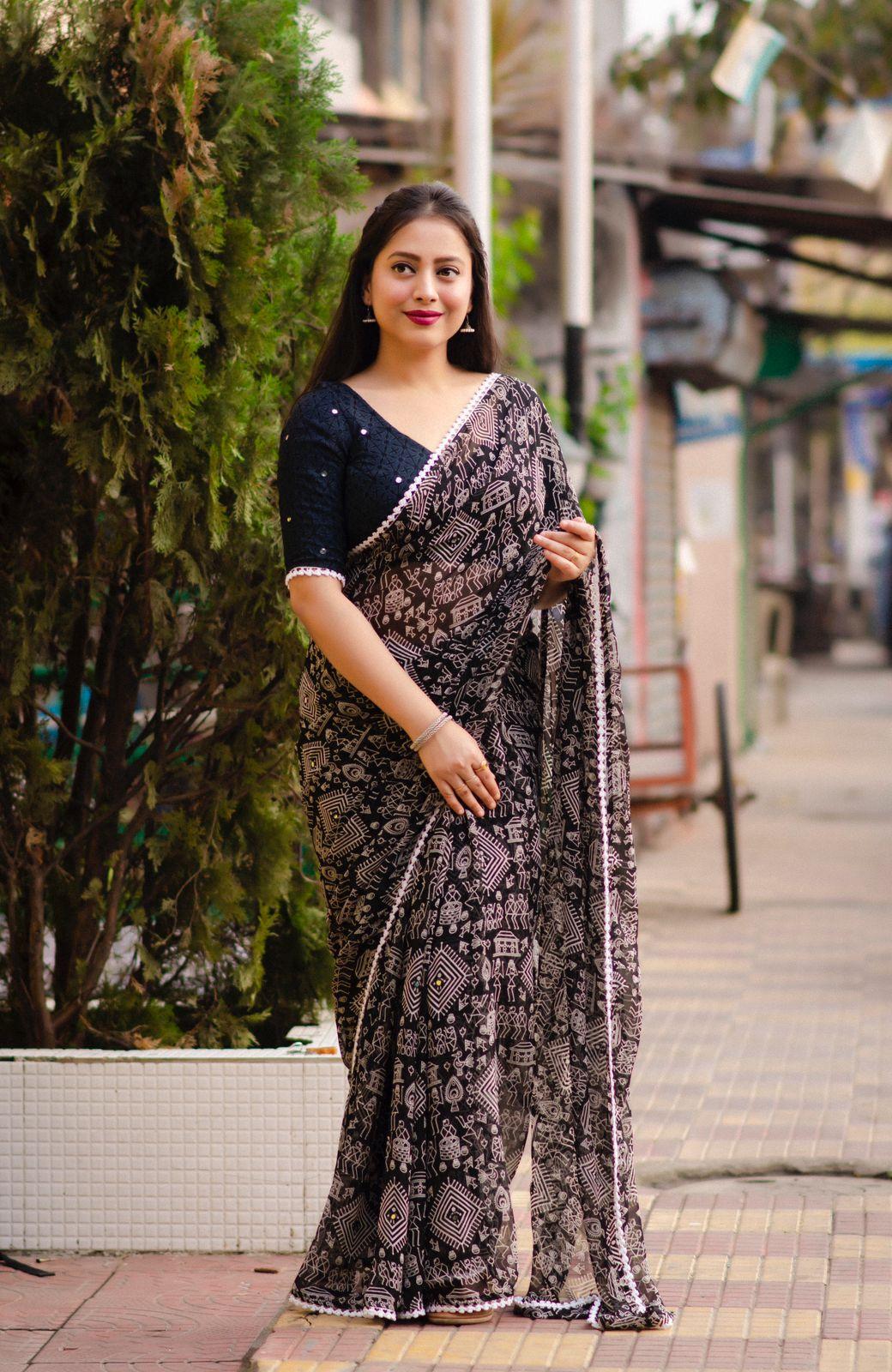 Black poly georgette saree with aari mirror work, Worli prints, and white patch lace border.