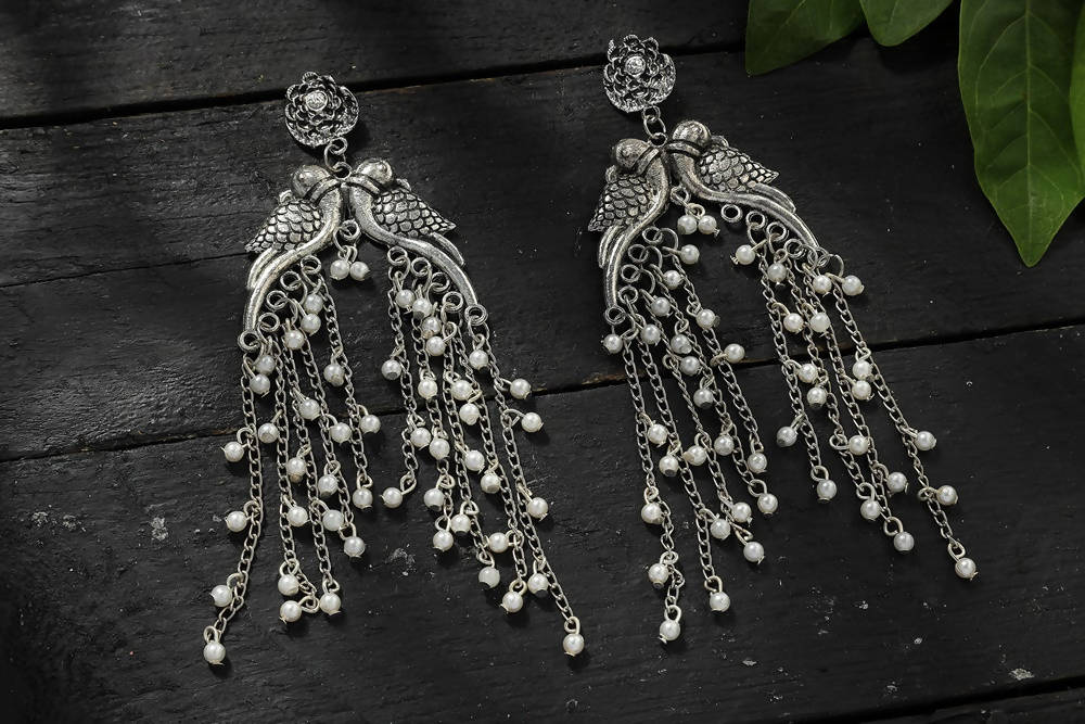 Silver-plated oxidised parrot design earrings on a neutral background
