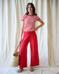A woman wearing vibrant red, high-waisted wide-leg knit pants with a relaxed cropped fit.