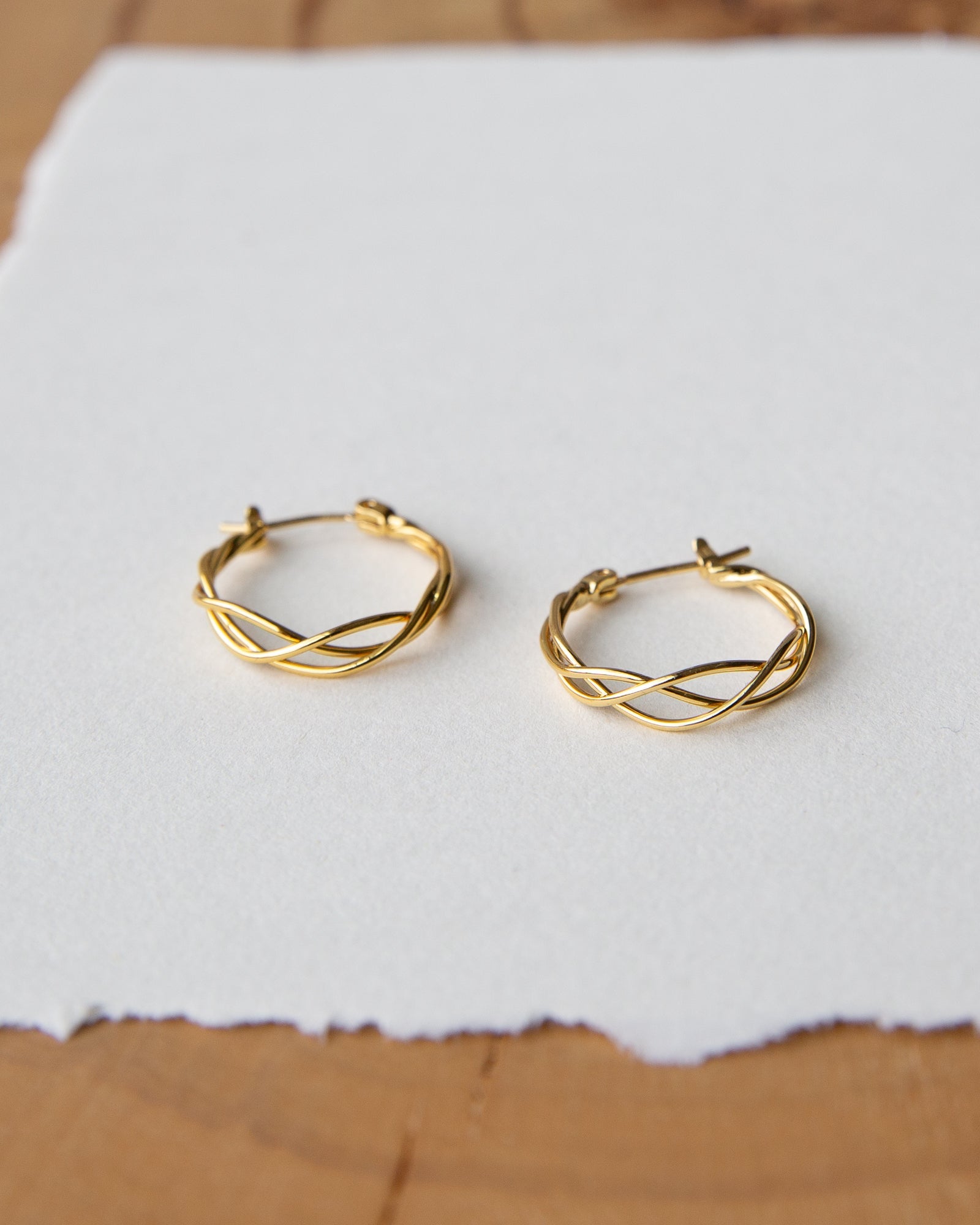 A pair of polished 14k gold-plated small braided hoop earrings for women