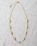 Mini flower necklace with a rose quartz colored glass stone on a 14K gold-plated cable chain.