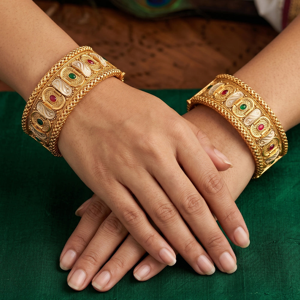 A set of high gold polish traditional bangles with intricate antique designs for festive wear