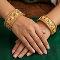 A set of high gold polish traditional bangles with intricate antique designs for festive wear
