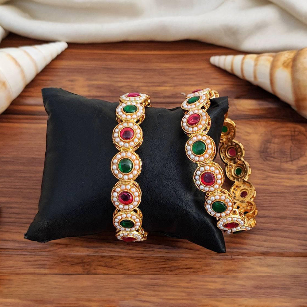 A pair of ornate antique-style bangles featuring full stone embellishments with a high gold polished finish.