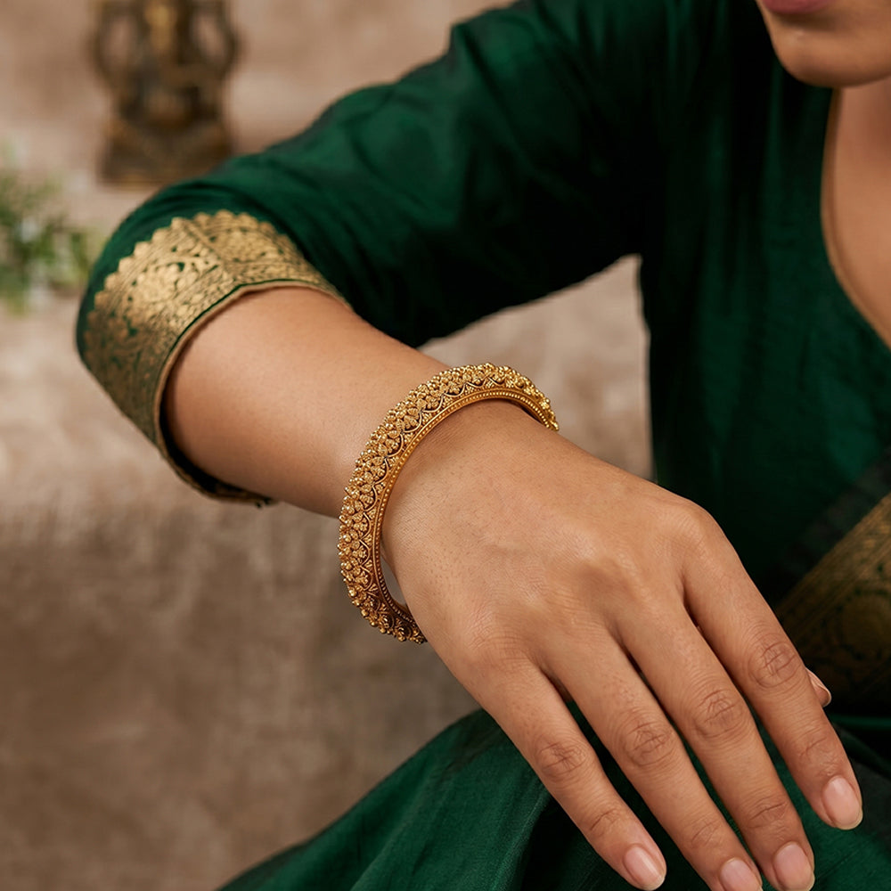A close-up of a traditional stone-studded antique finish bangle set for ethnic wedding attire