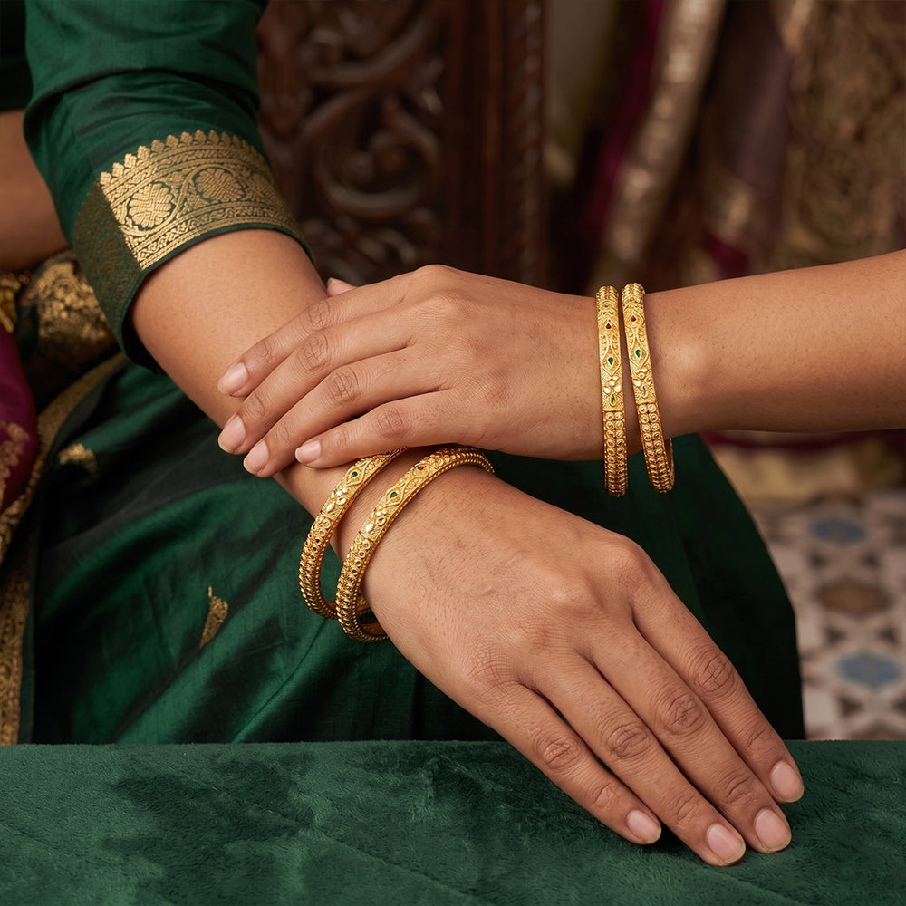 Antique designer gold bangle set featuring intricate traditional patterns.