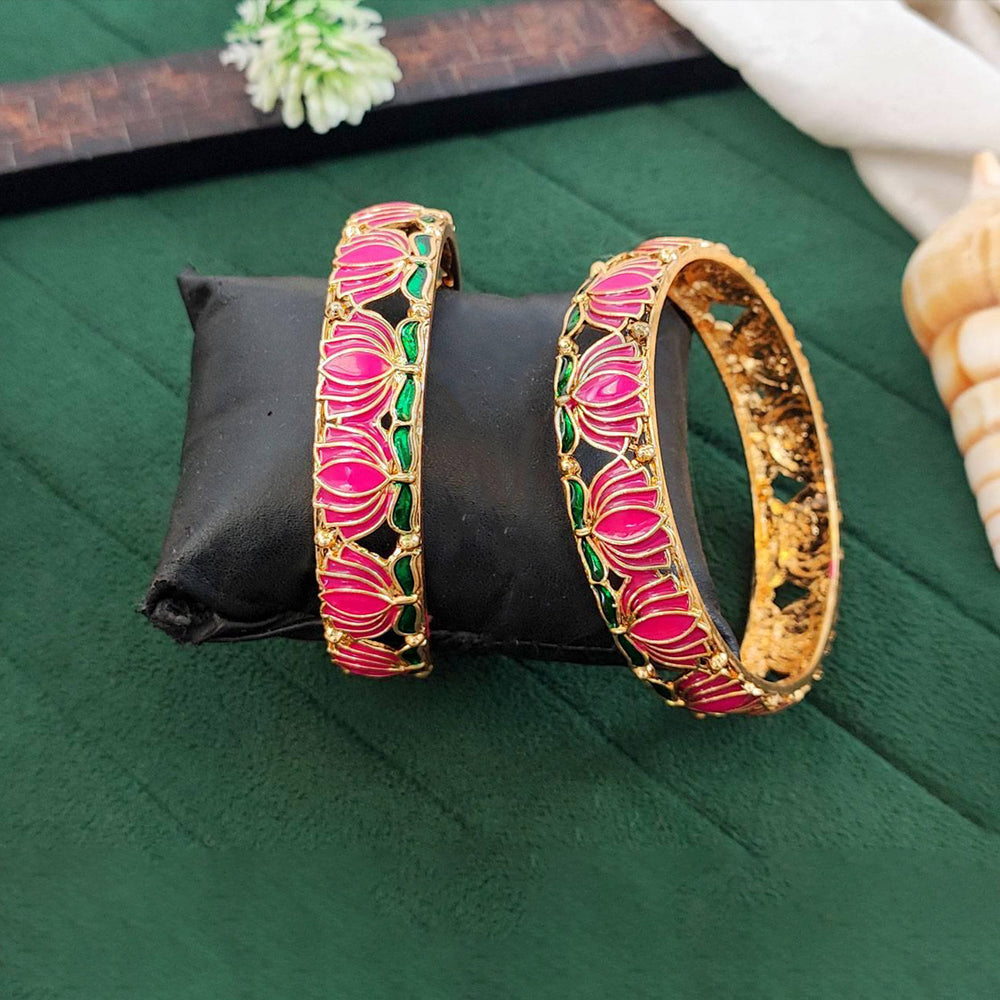 Close-up of elegant ethnic gold finish lotus-patterned bangles on a neutral background