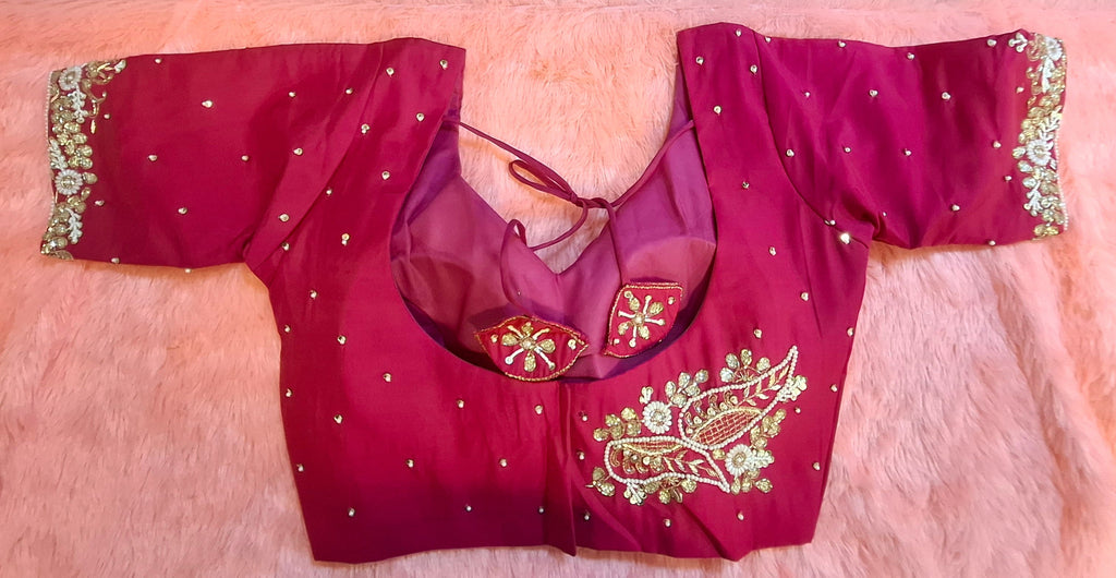Hot pink silk readymade blouse heavily adorned with hand-embroidered zardosi, beads, and pearls.