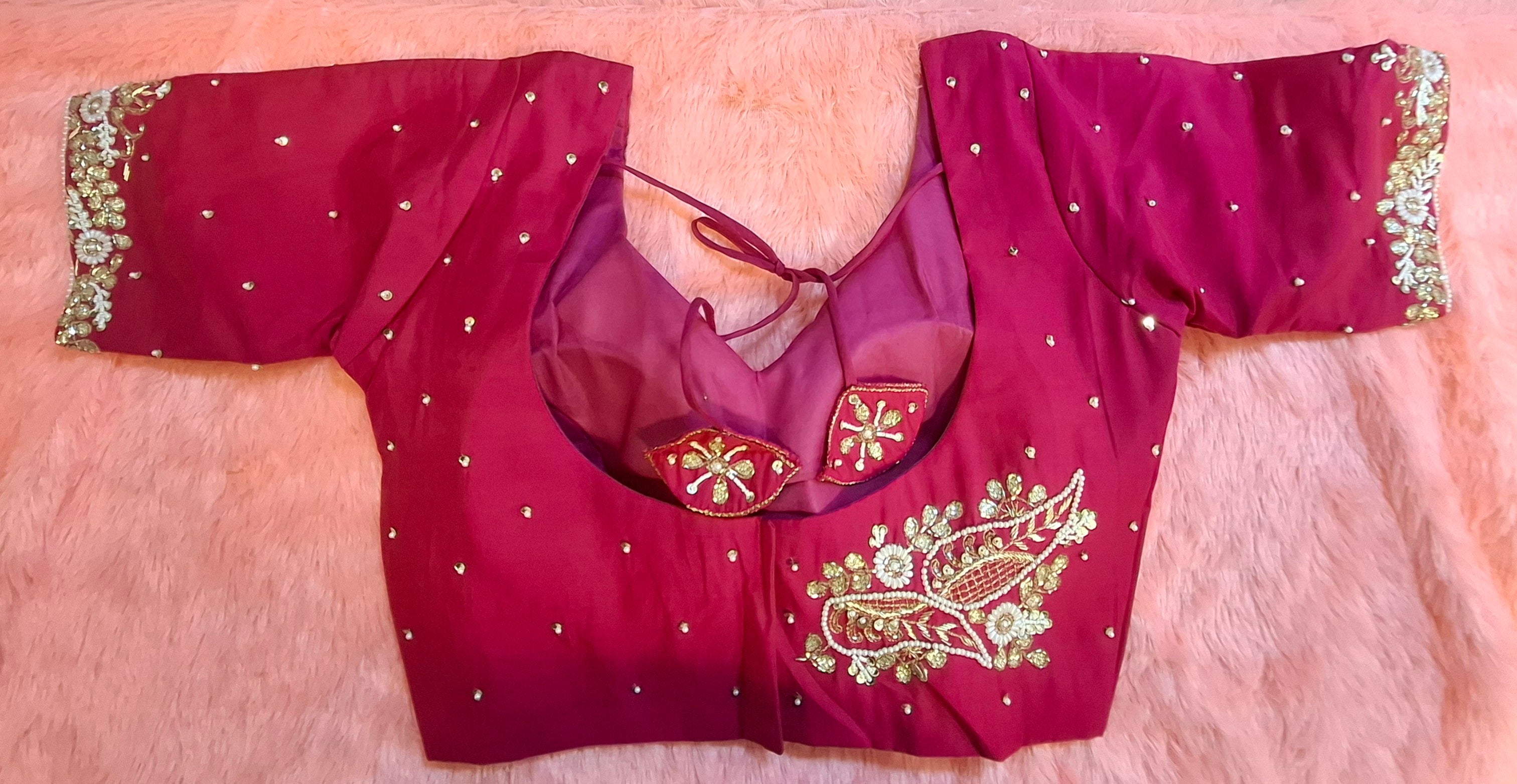 Hot pink silk readymade blouse heavily adorned with hand-embroidered zardosi, beads, and pearls.