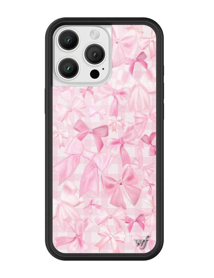 Close up shot of the Bow Beau iPhone case featuring a pink bow pattern and black protective bumper.