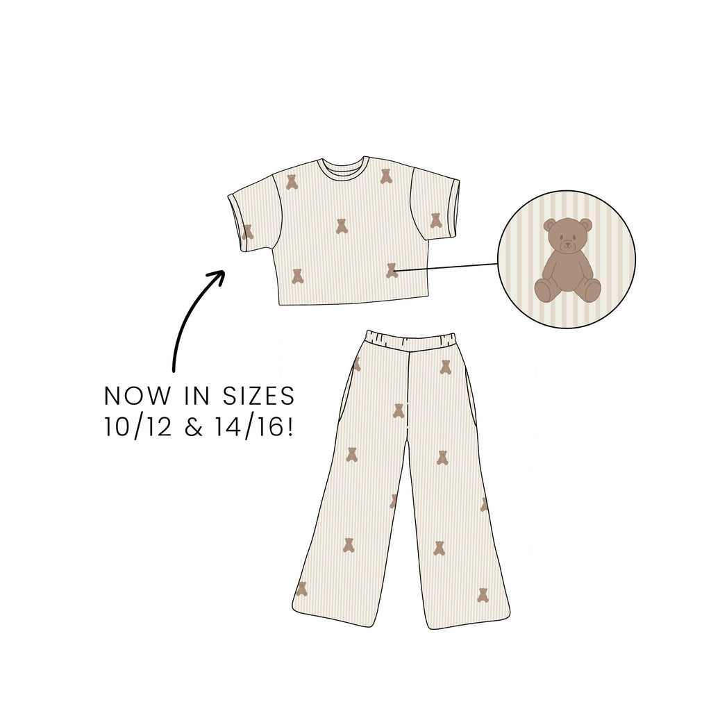 Kids bamboo lounge set with short-sleeve boxy top and wide-leg pants featuring a teddy bear print on a striped background