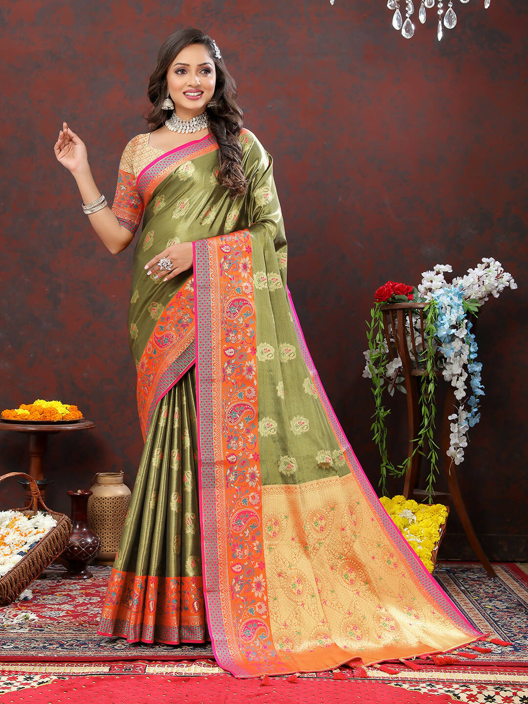 Traditional Mehndi-colored Kanjivaram silk saree with intricate gold Zari weaving and pink/orange accents.