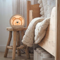 Minimalist bear-shaped LED night light in light-wood and white on a nursery nightstand