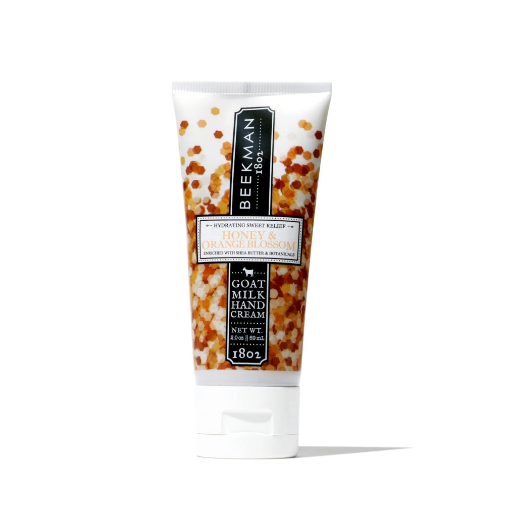 A 2 oz tube of Beekman 1802 Honey & Orange Blossom Hand Cream featuring honey and citrus botanical imagery.