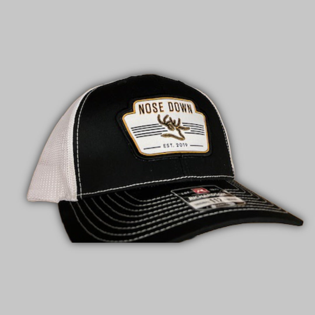 Vintage white trucker hat with a prominent woven logo patch.