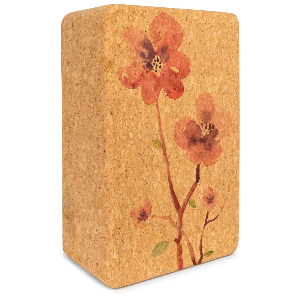 Tan and brown cork yoga block with a floral pattern and stylized lotus logo