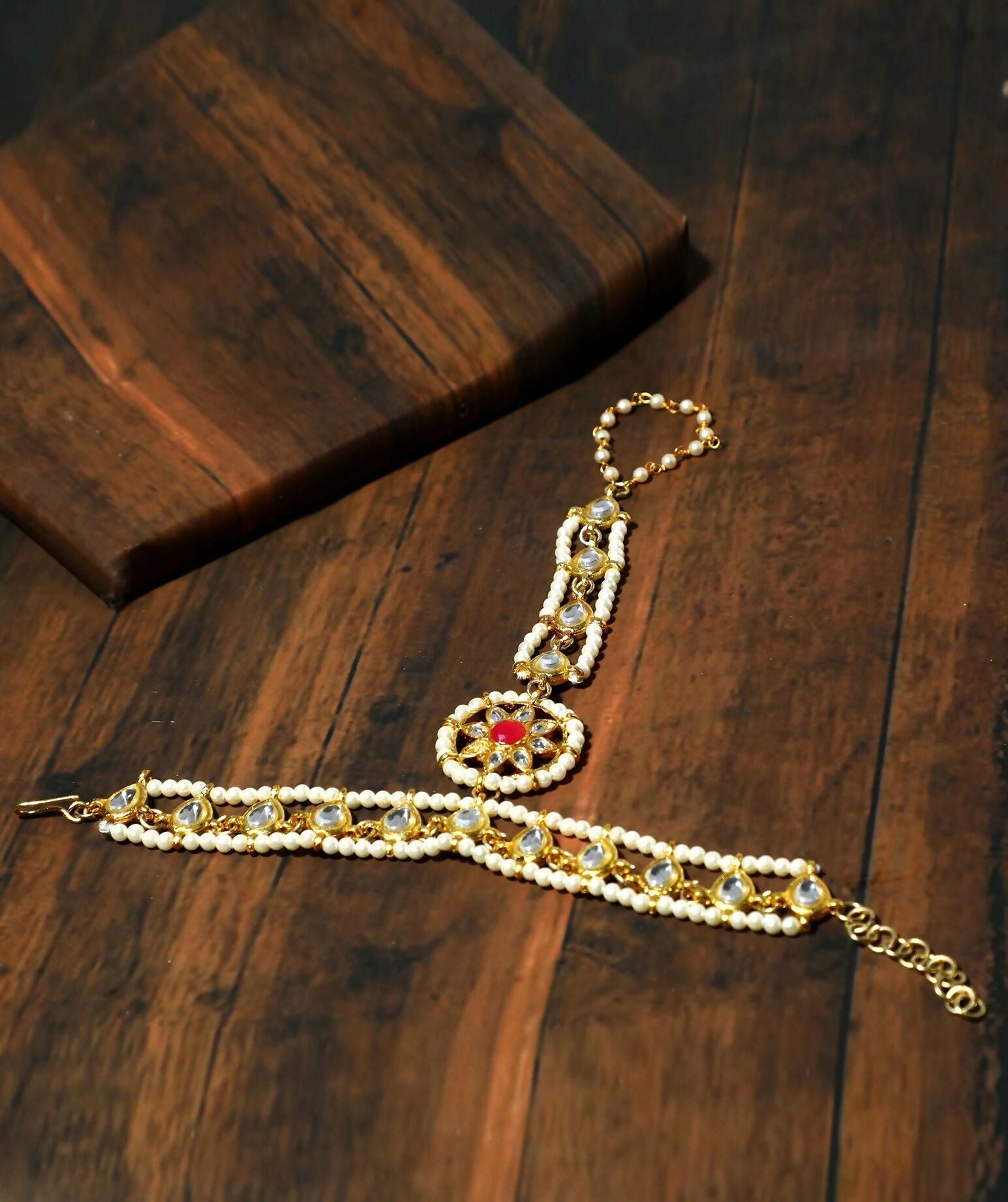 Traditional red and gold Kundan Hathphool bracelet, handcrafted brass accessory for Indian weddings